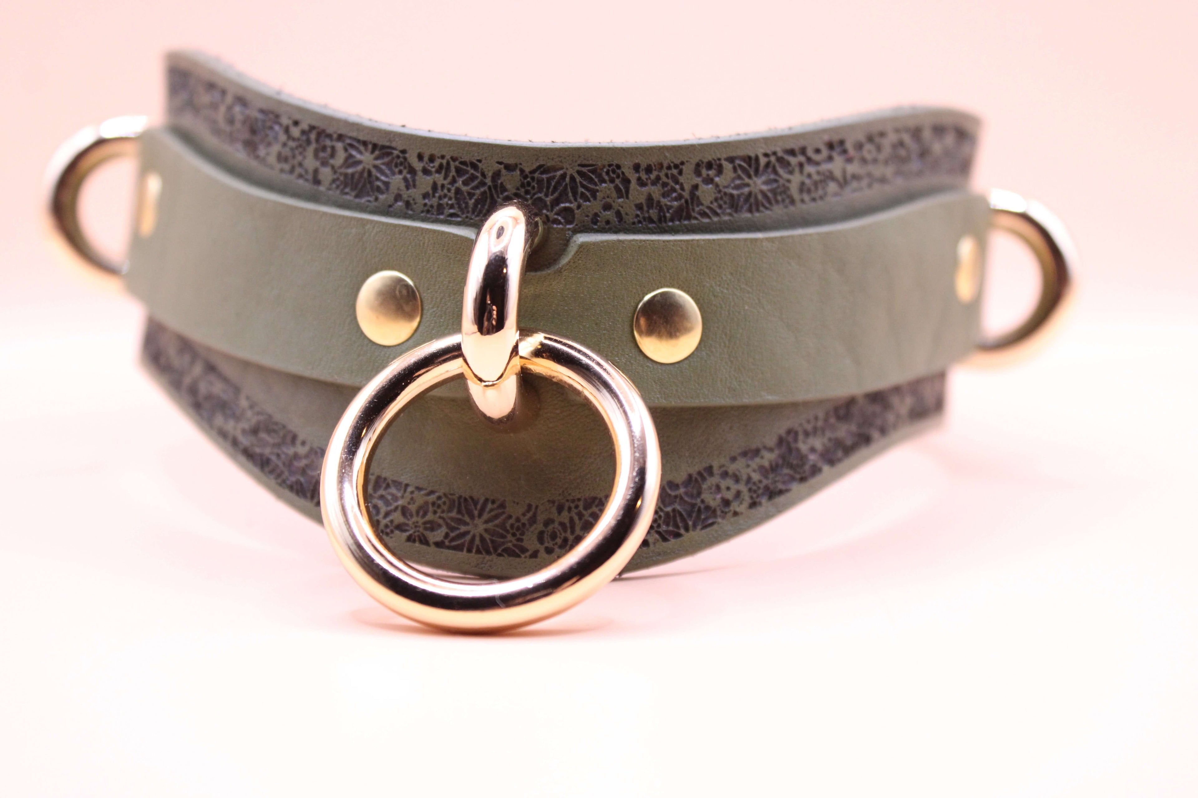 Avocado green leather choker with gold rings and floral patterns, designed as a stylish submissive necklace.