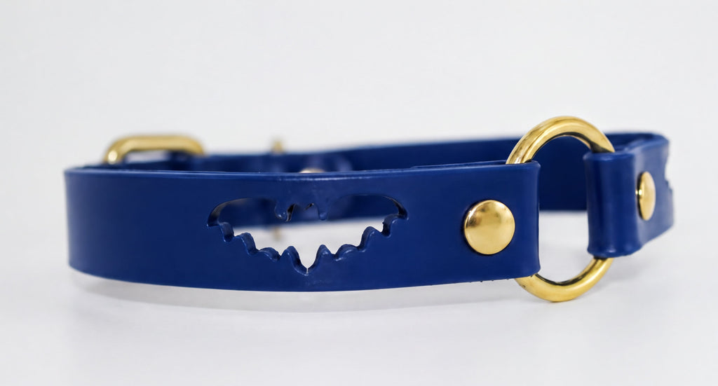 A blue leather collar with a bat-shaped cutout and two gold-colored buckles.