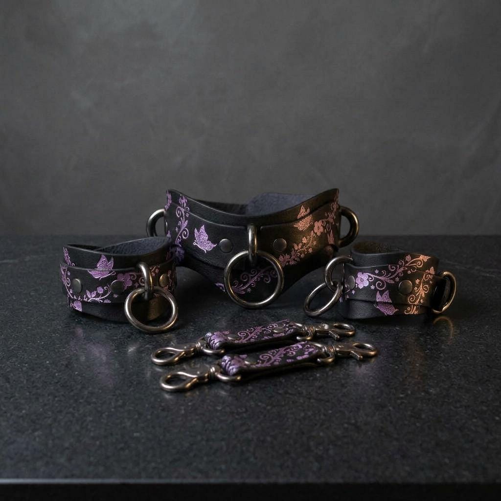 a collection of leather straps and buckles in shades of purple and black, arranged on a dark surface.