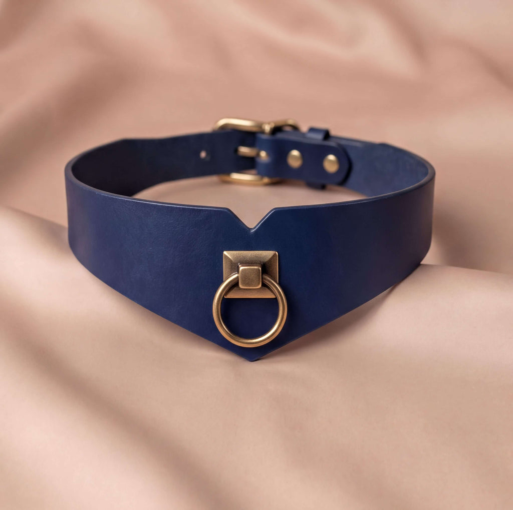 A navy blue choker collar with a gold-colored metal ring and buckle.