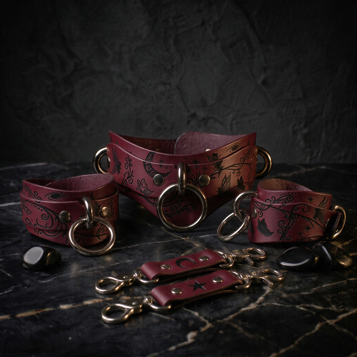 A set of burgundy leather choker necklaces and straps with intricate designs, including floral and celestial motifs, displayed on a dark surface.