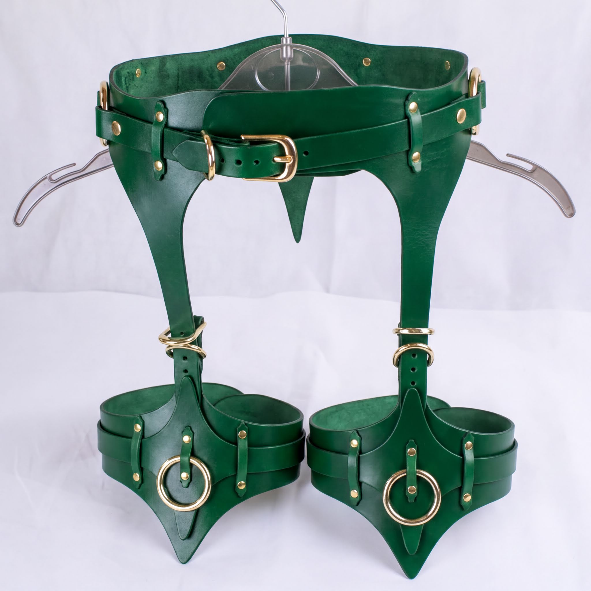 A pair of green leather thigh-high boots with a unique design and multiple buckles and straps.