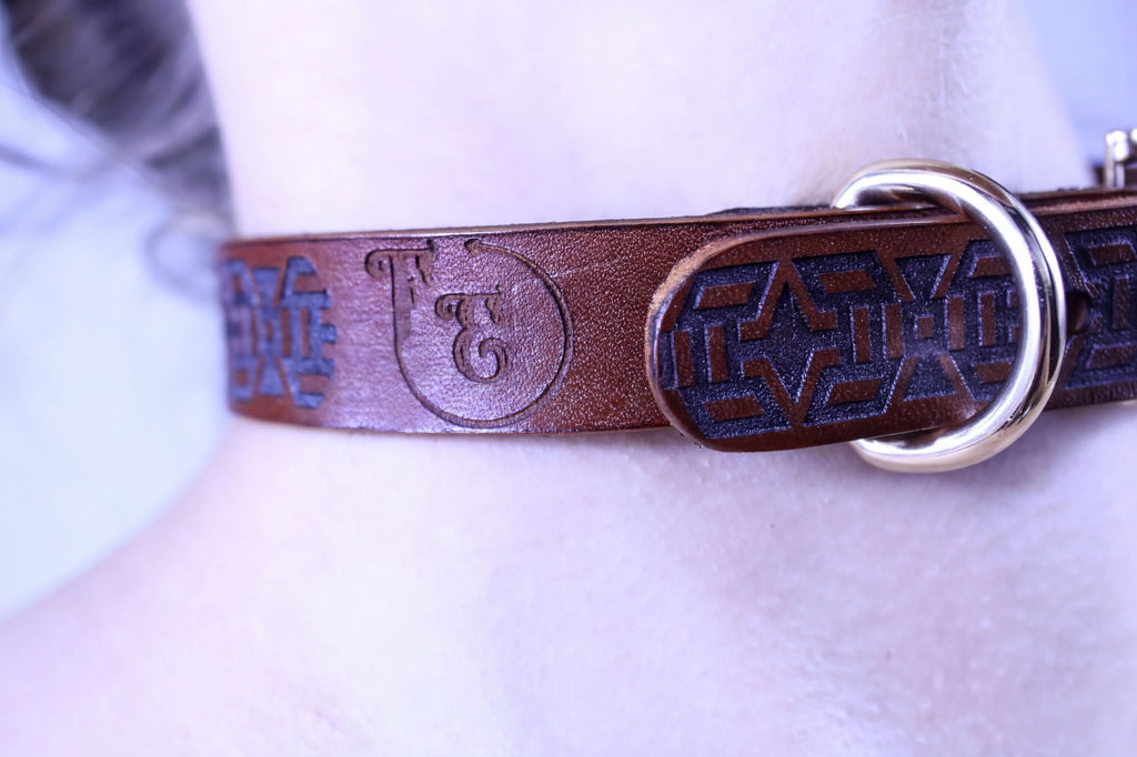 Handmade leather bondage collar with tribal motif, perfect for BDSM and discreet day wear, showcasing elegance and strength.