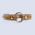 A tan leather collar with a floral design and metal ring, featuring two silver buttons.