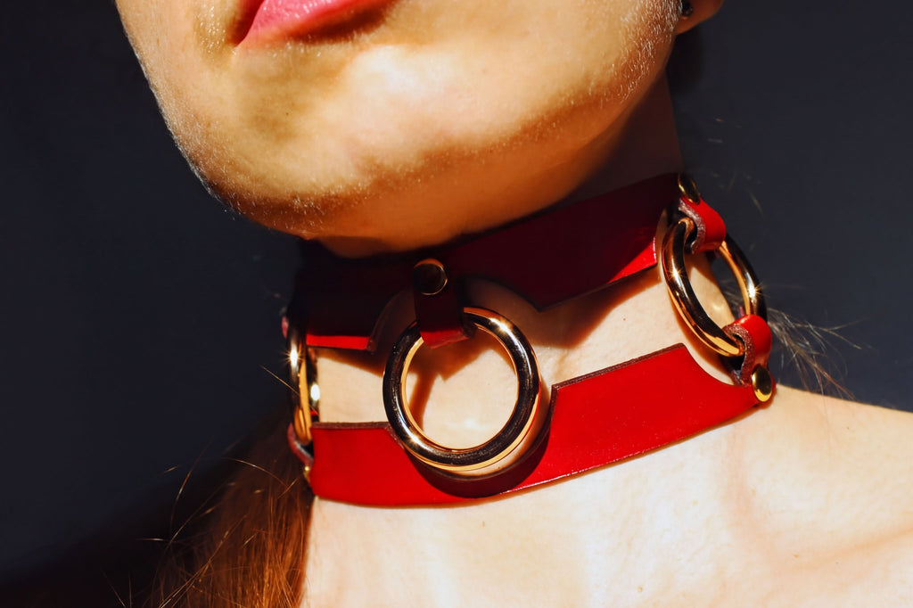 Bold red leather BDSM collar with metal rings, perfect for submissive jewelry and bondage aesthetics.