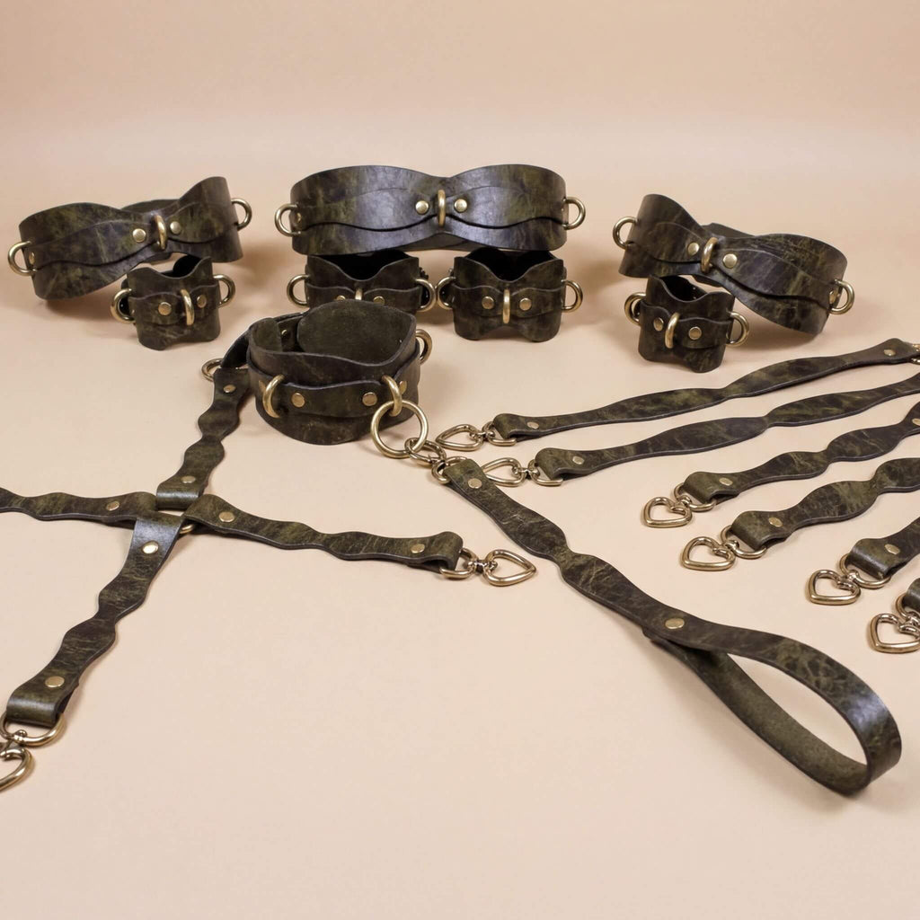 A collection of leather straps and buckles arranged on a beige background.