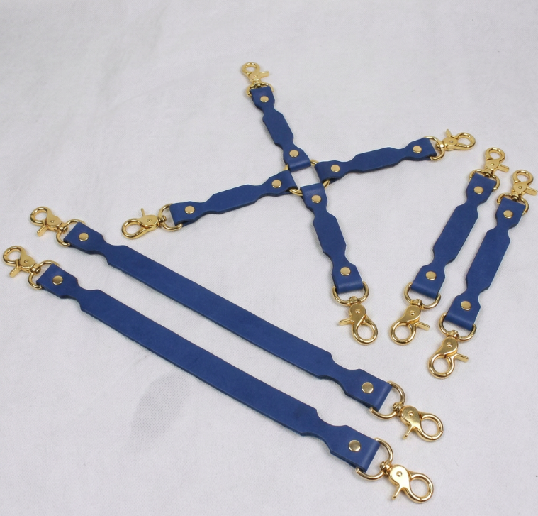 A set of blue leather straps with gold metal clasps, arranged in a pattern on a white background.