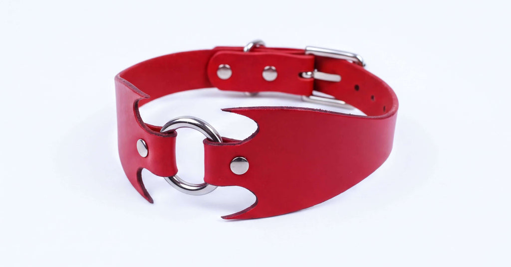 A red leather choker collar with a metal ring and buckle.