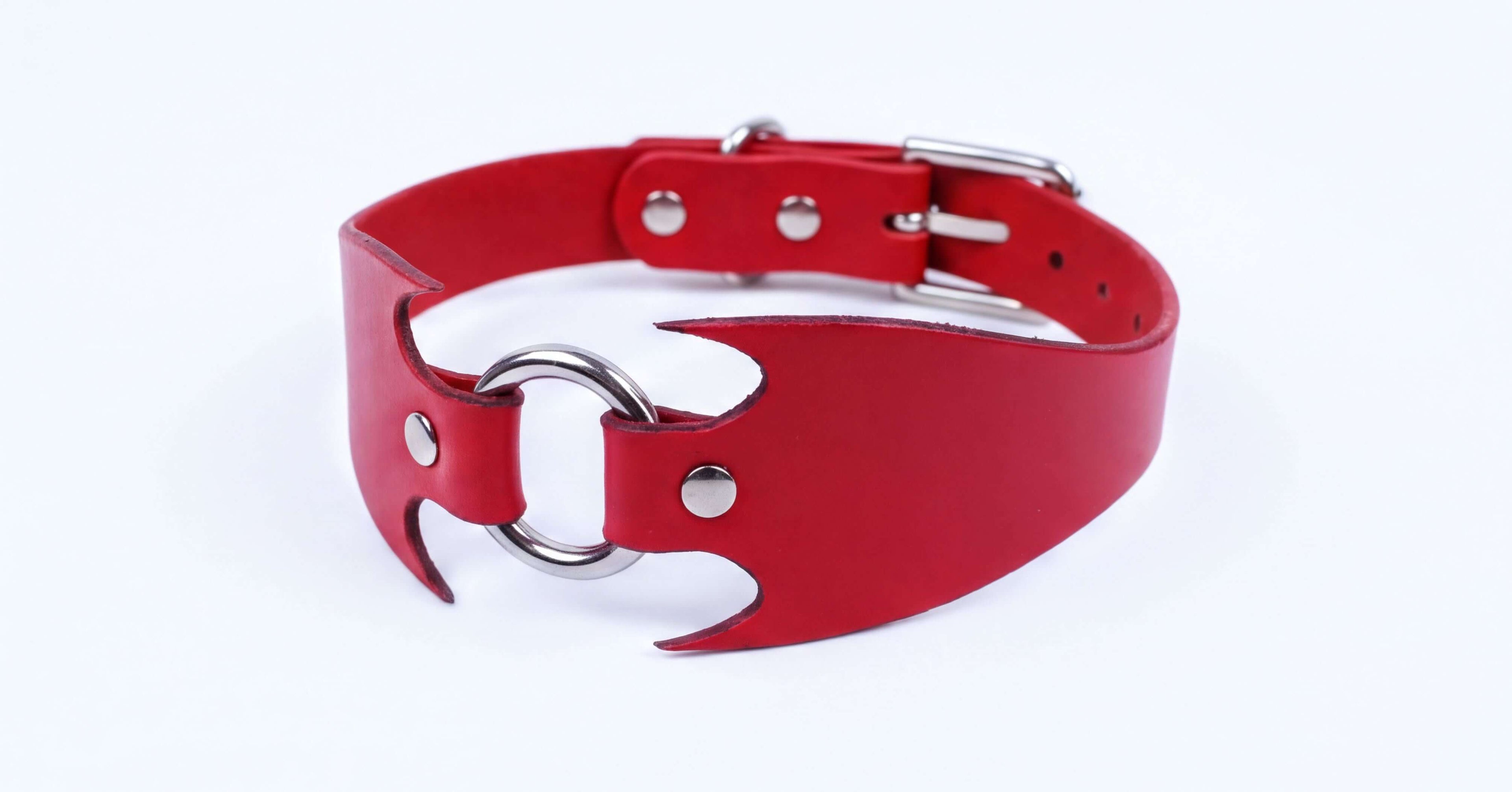 A red leather choker collar with a metal ring and buckle.