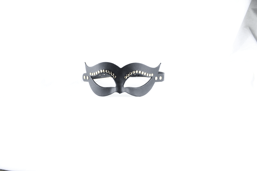 A black mask with decorative elements on it is displayed against a white background.