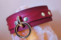 Crimson red BDSM collar with O-ring and gold-tone studs, perfect for submissive jewelry and bondage gear.