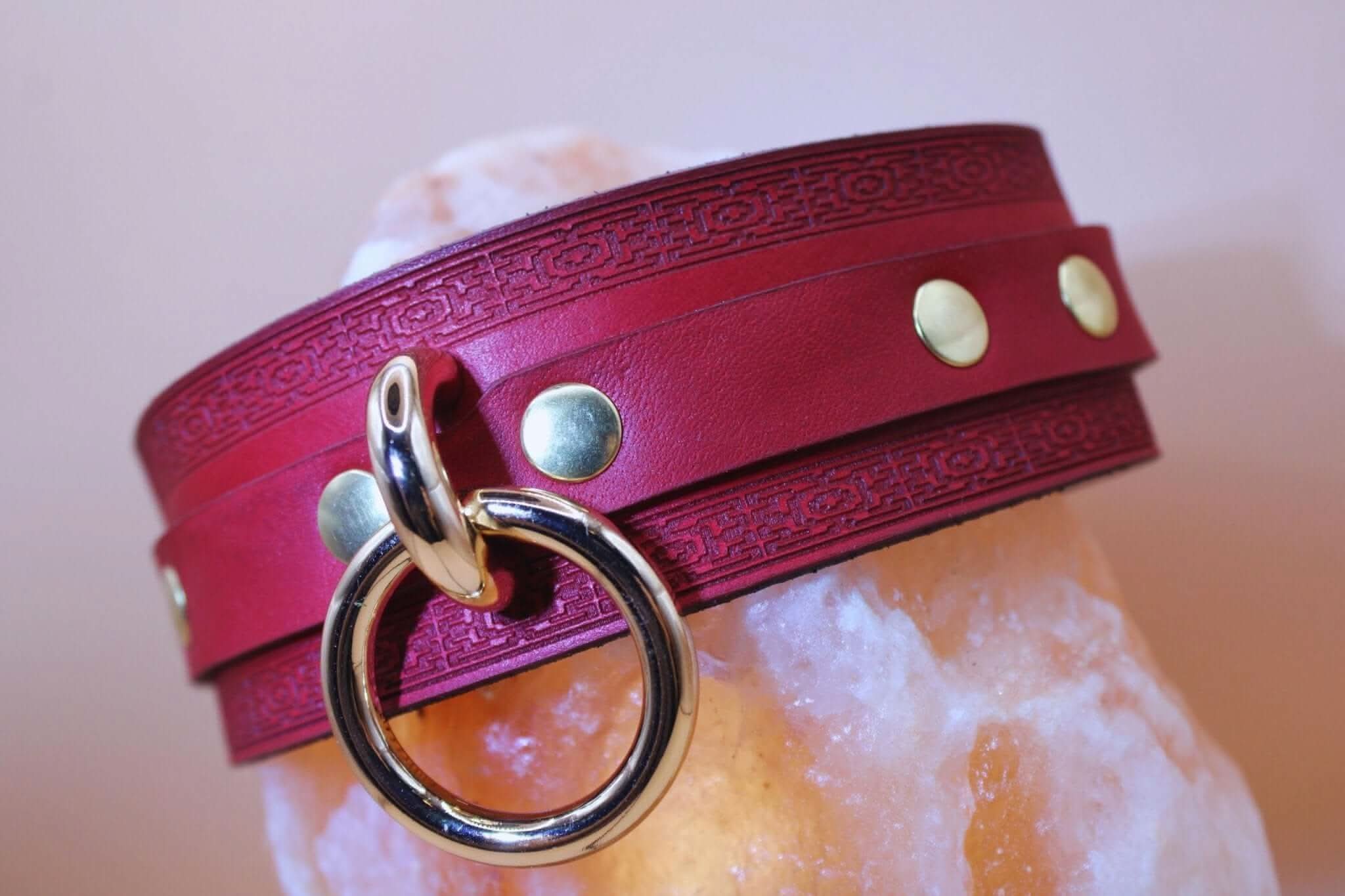 Crimson red BDSM collar with O-ring and gold-tone studs, perfect for submissive jewelry and bondage gear.