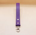 A purple leather strap with a metal clasp and hook attached to it.