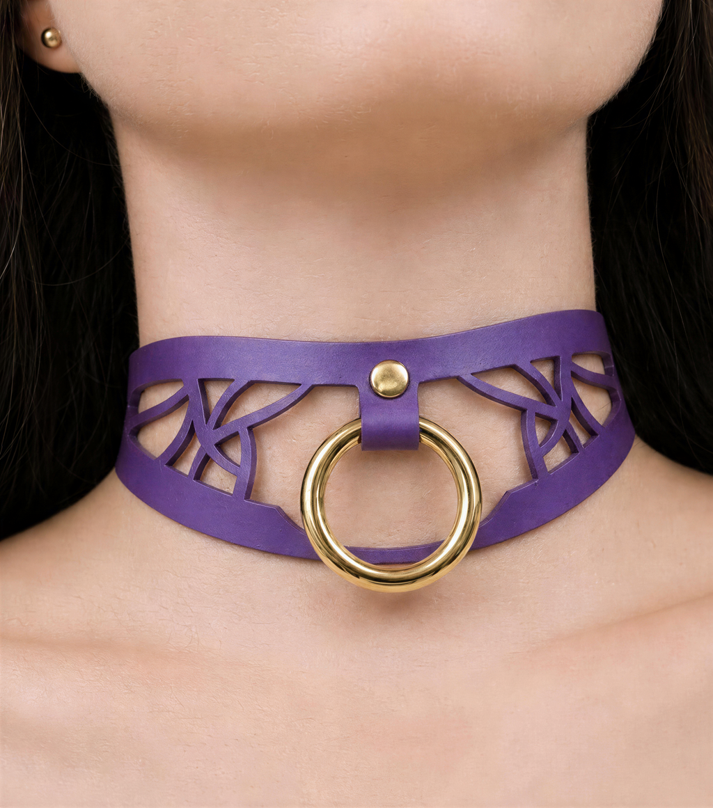 A close-up view of a woman's neck and chest area wearing a purple choker necklace with a gold ring.