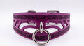 A purple leather choker collar with a metal ring and a decorative pattern on the surface.