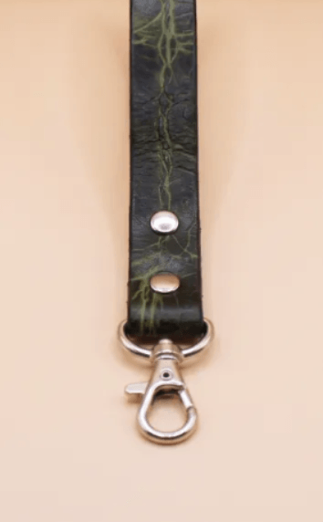 A black leather strap with a silver metal clasp and a green pattern on it.