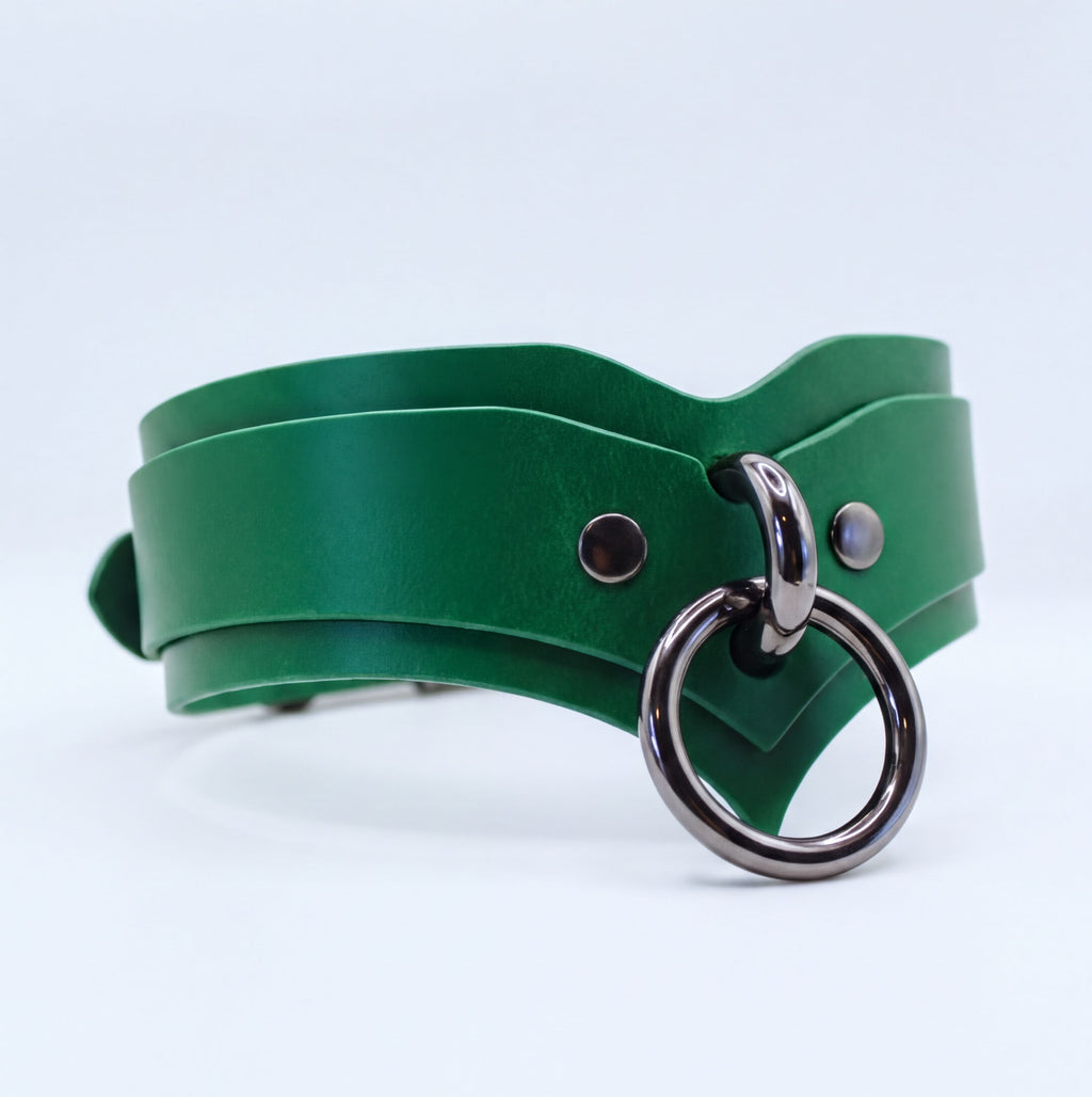 A green leather choker necklace with a metal ring and two metal studs on the front.