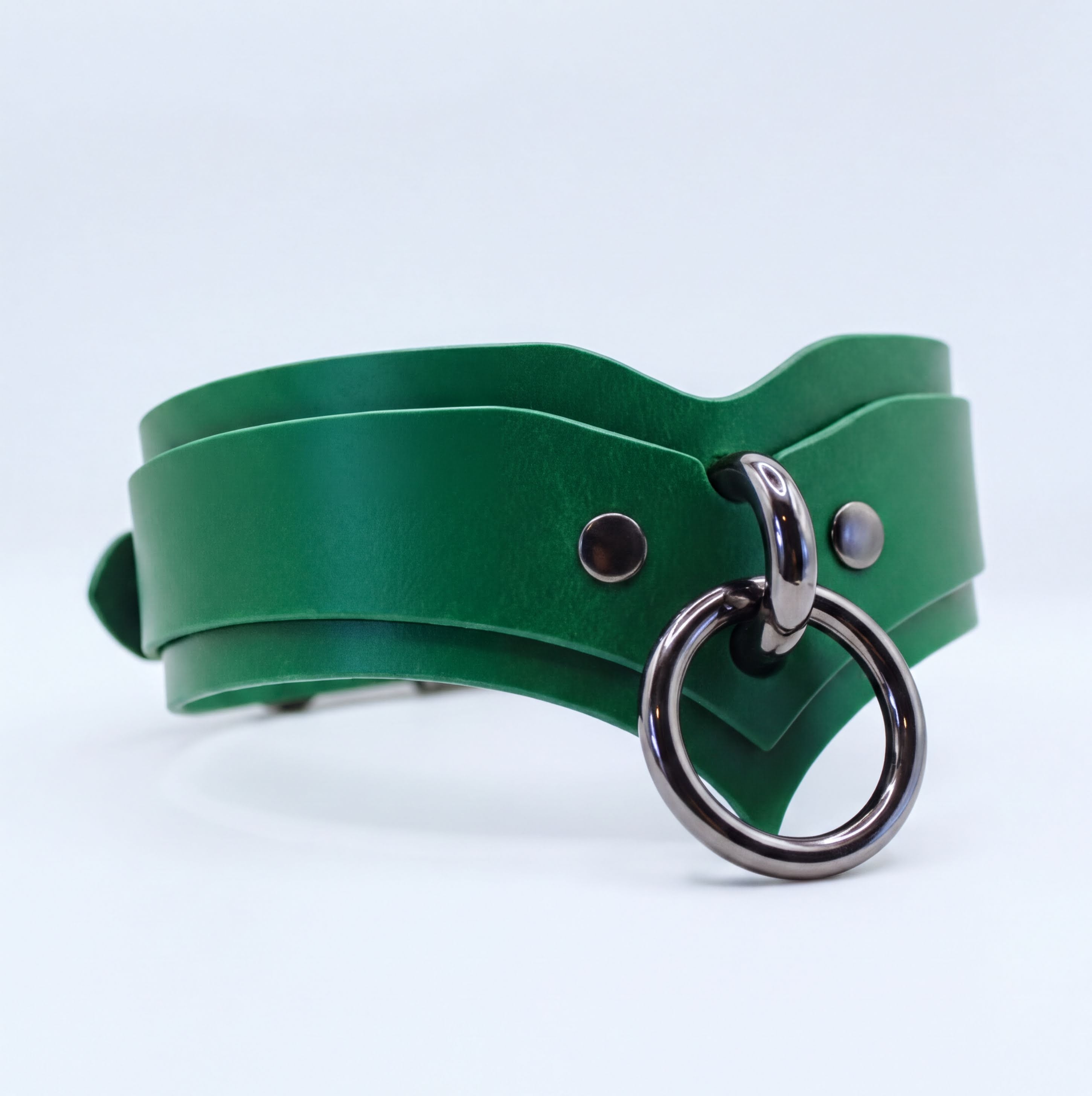 A green leather choker necklace with a metal ring and two metal studs on the front.