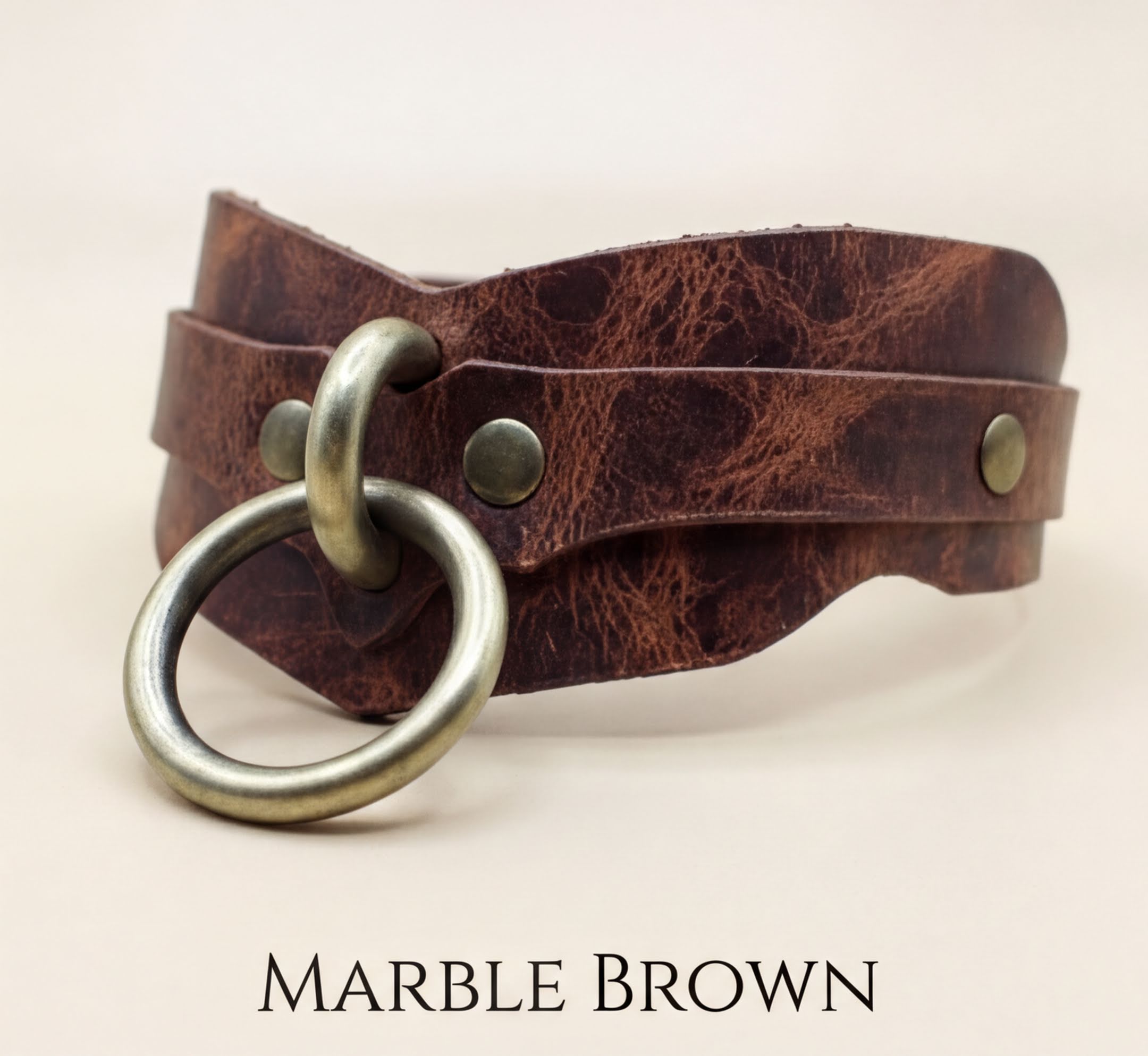 Marble brown leather choker necklace with a metal ring and two metal studs.