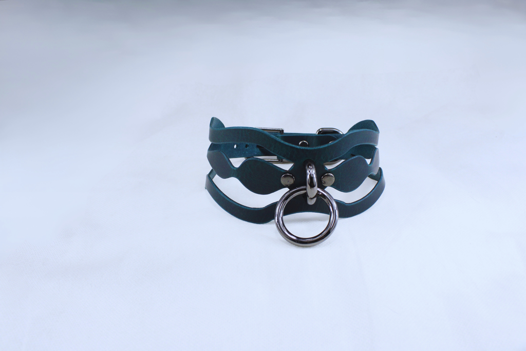 A dark green leather choker necklace with a metal ring and buckle.
