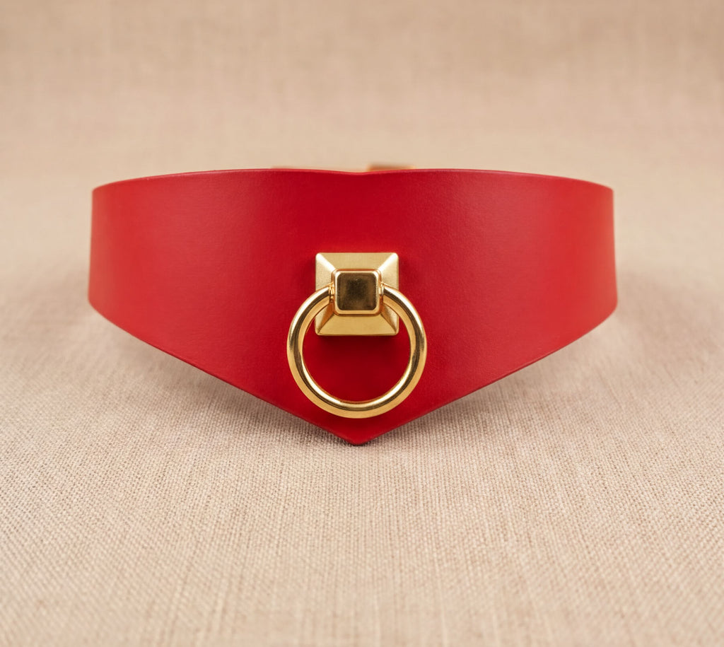 A red leather choker necklace with a gold-colored metal ring on the front.