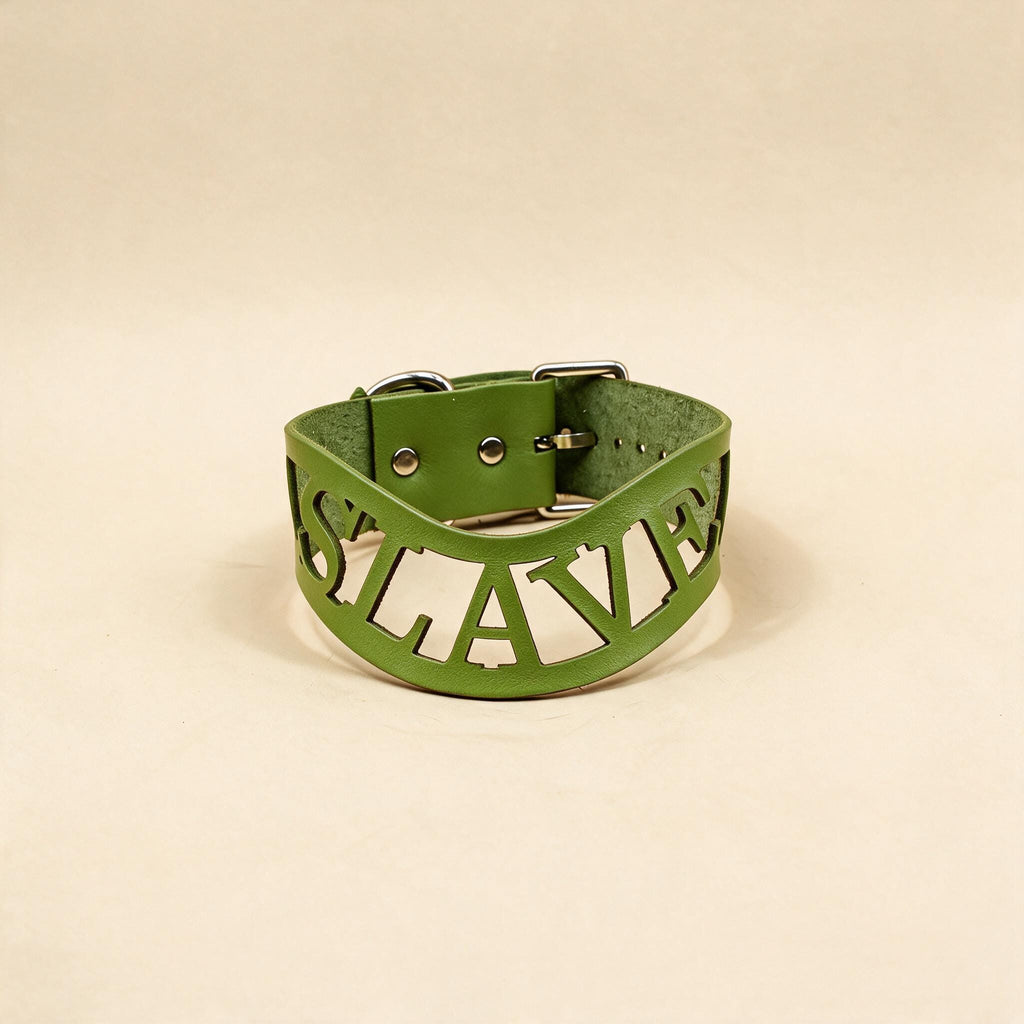 A green leather choker necklace with the word "SLAVERY" cut out in the shape of the word "SLAVERY" on it.
