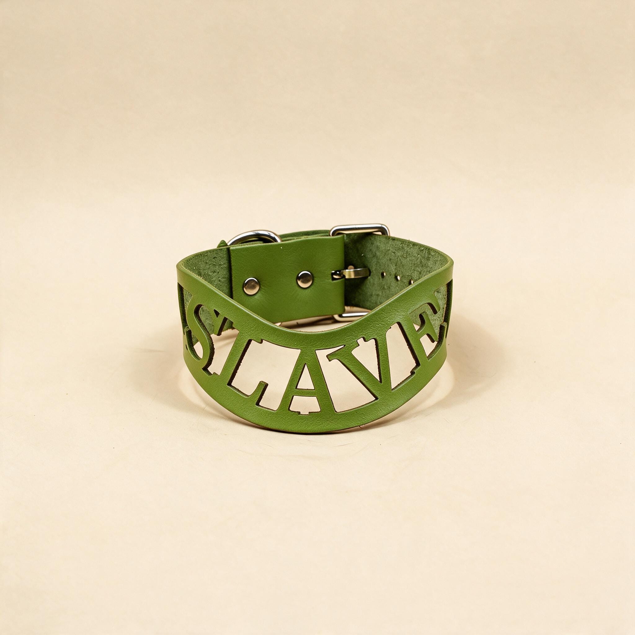 A green leather choker necklace with the word "SLAVERY" cut out in the shape of the word "SLAVERY" on it.