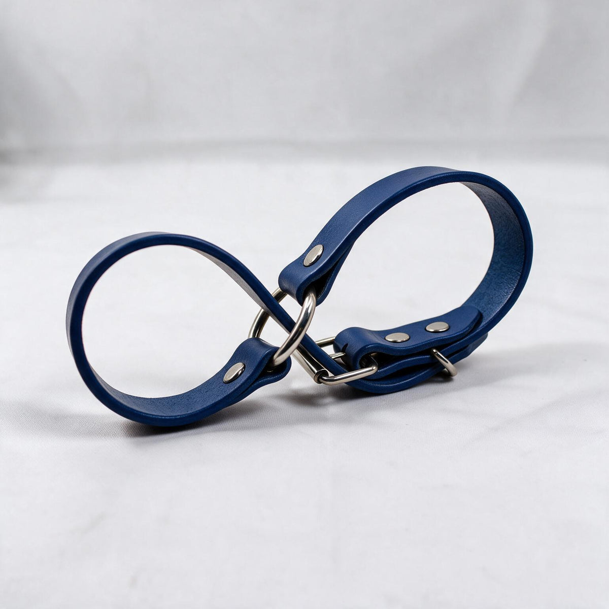 A blue leather strap with metal buckles and clips is shown against a white background.