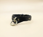 A black leather choker necklace with a metal ring and buckle.