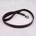 A brown leather dog leash with a heart-shaped charm attached.