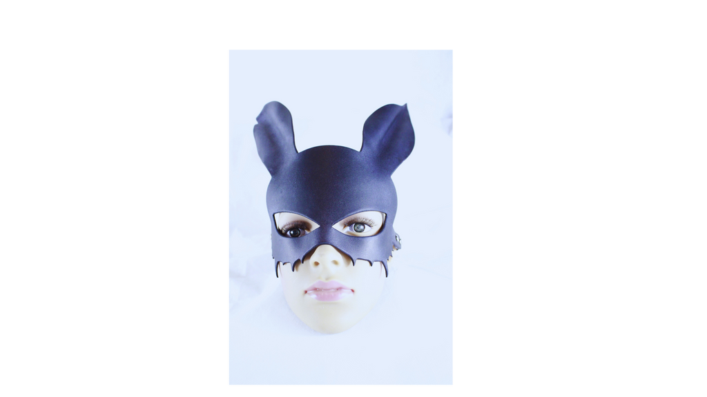 A person wearing a black cat mask with large ears, looking directly at the camera.