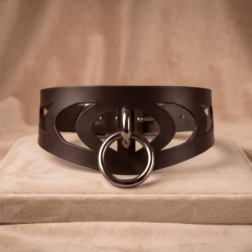 A brown leather choker necklace with a metal ring and cutout design.