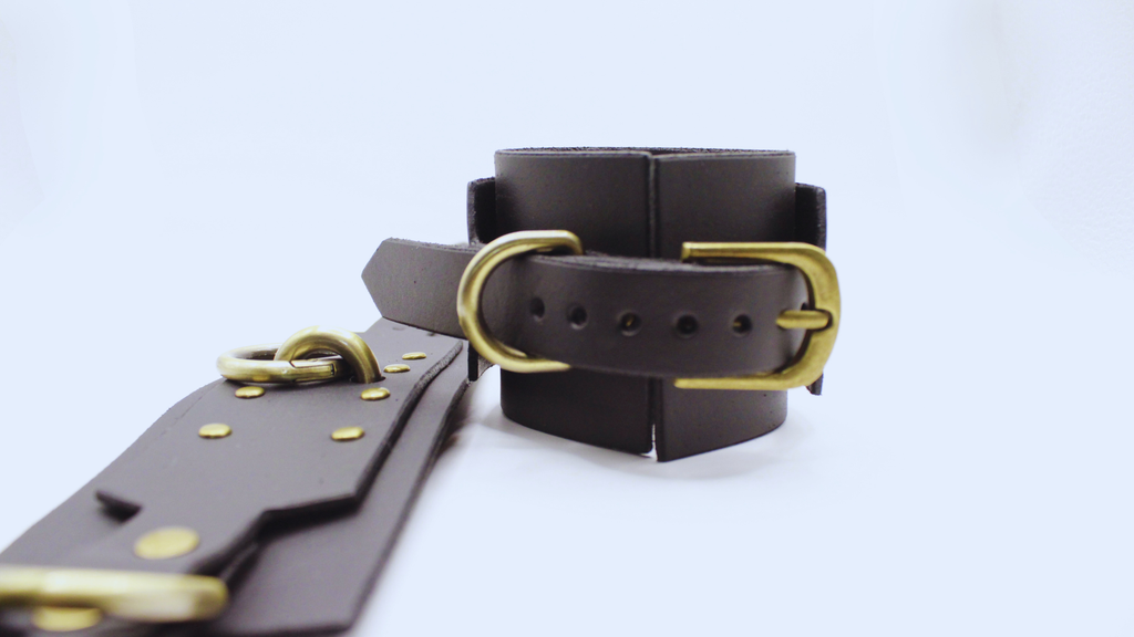 A black leather strap with a gold buckle is shown in the image.