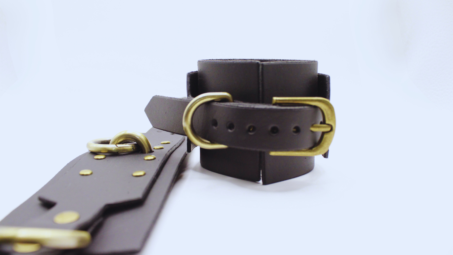 A black leather strap with a gold buckle is shown in the image.