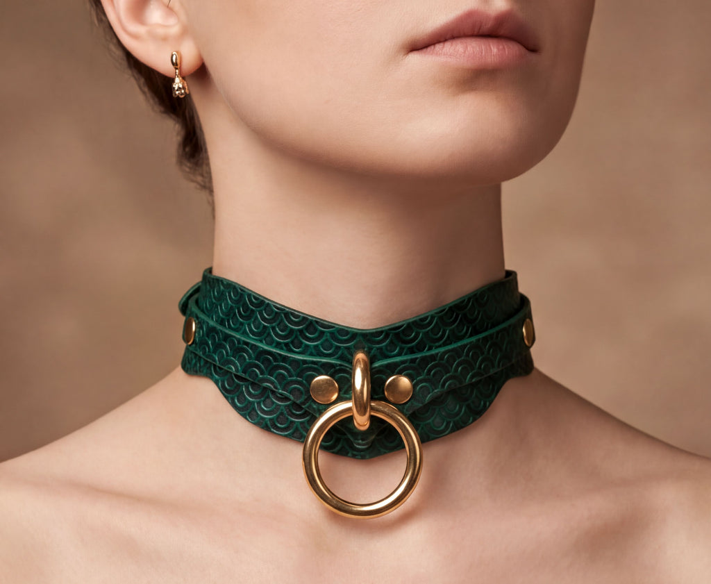 A close-up of a woman's neck and chin wearing a green leather choker necklace with a gold ring and buckle.