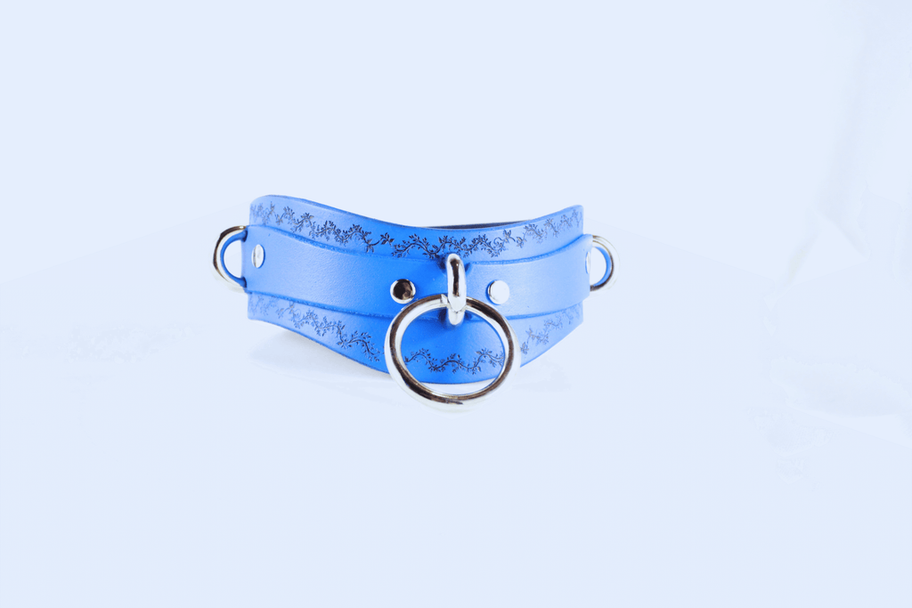 Floral Vine Posture Collar in blue leather featuring silver O-ring and floral motif edges for a stylish neck accessory.