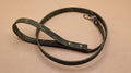 A green leash with a metal clasp and buckle is shown on a beige surface.