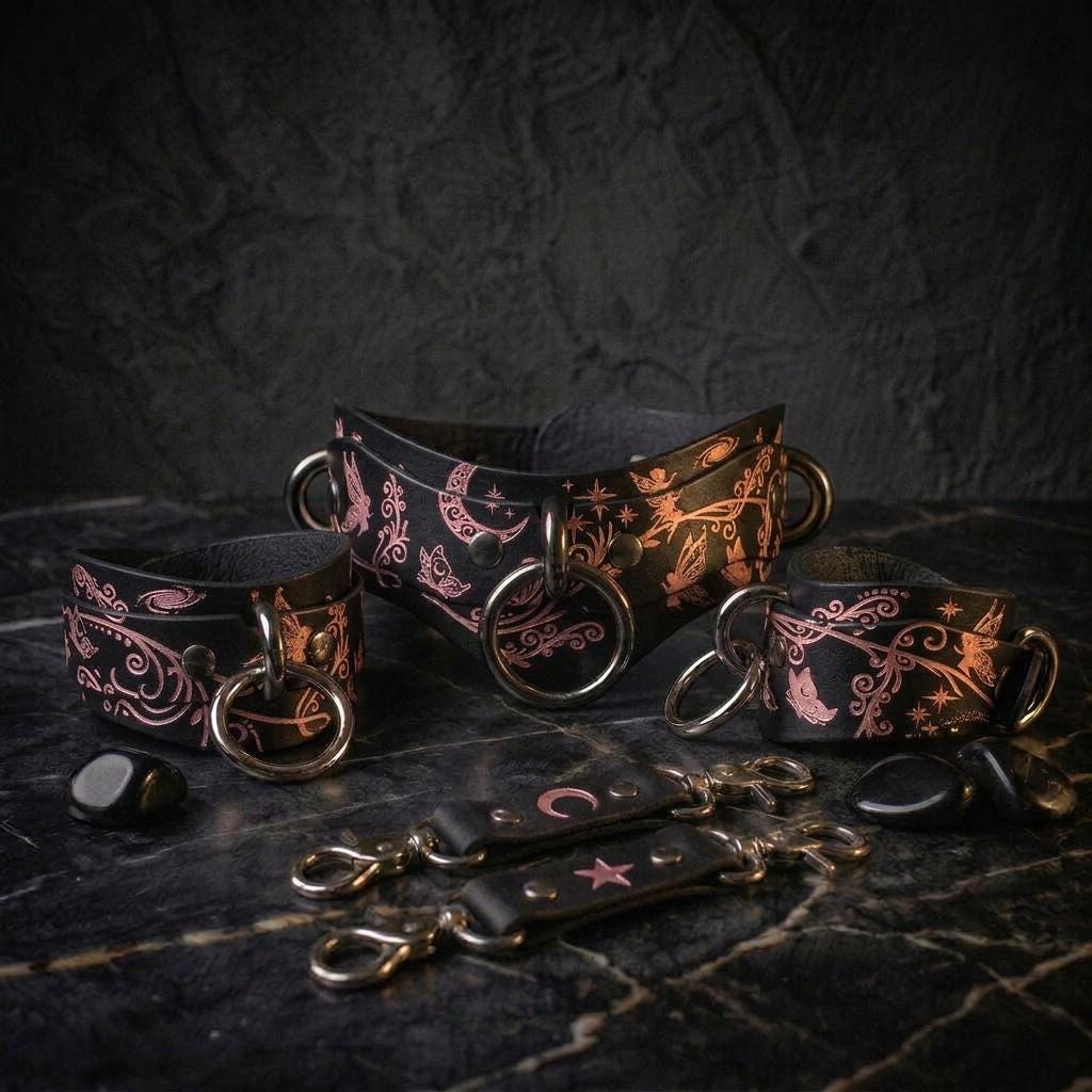 a collection of leather straps and charms with intricate designs, including floral patterns and celestial motifs, arranged on a dark surface.