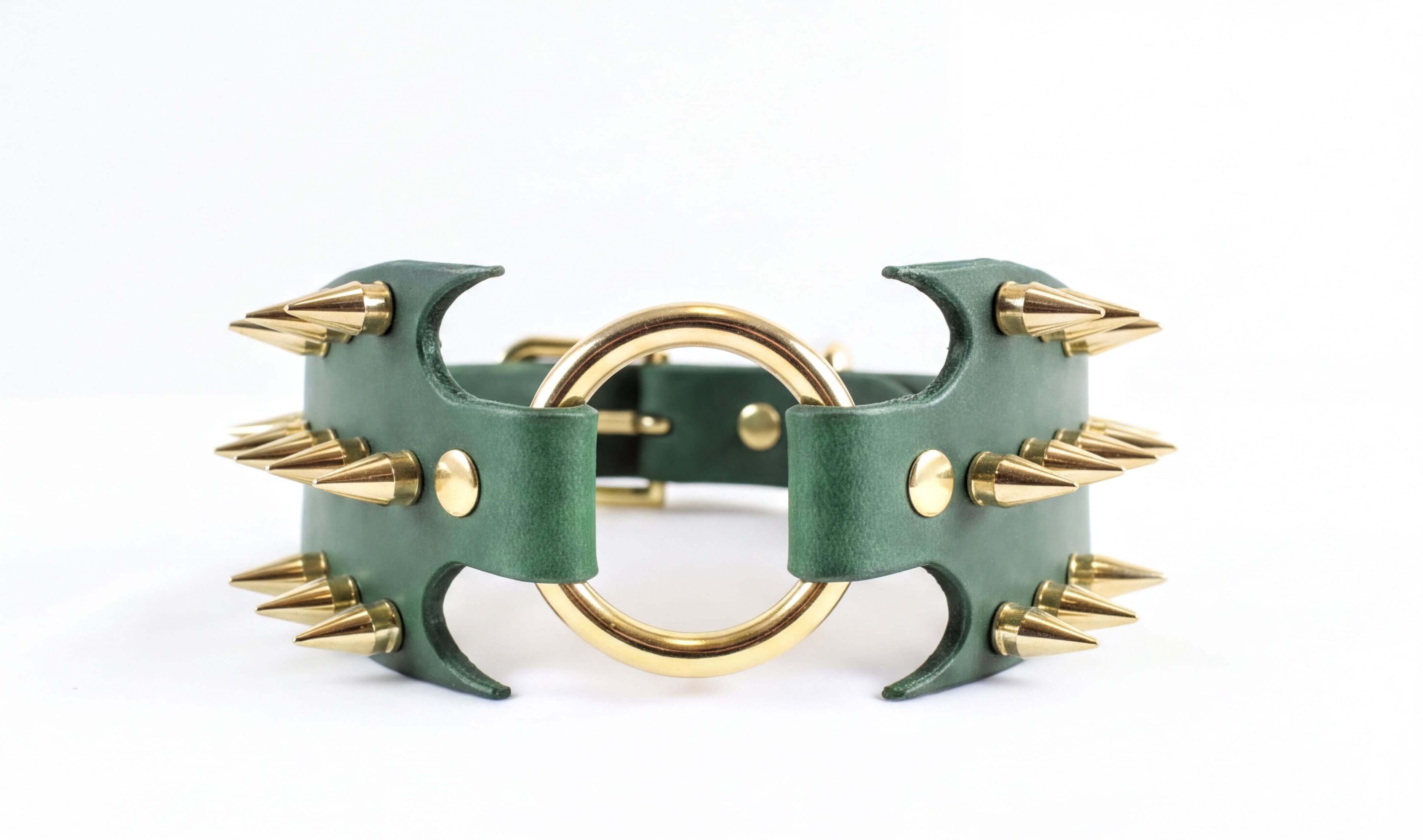 A green leather choker necklace with gold spikes protruding from it.