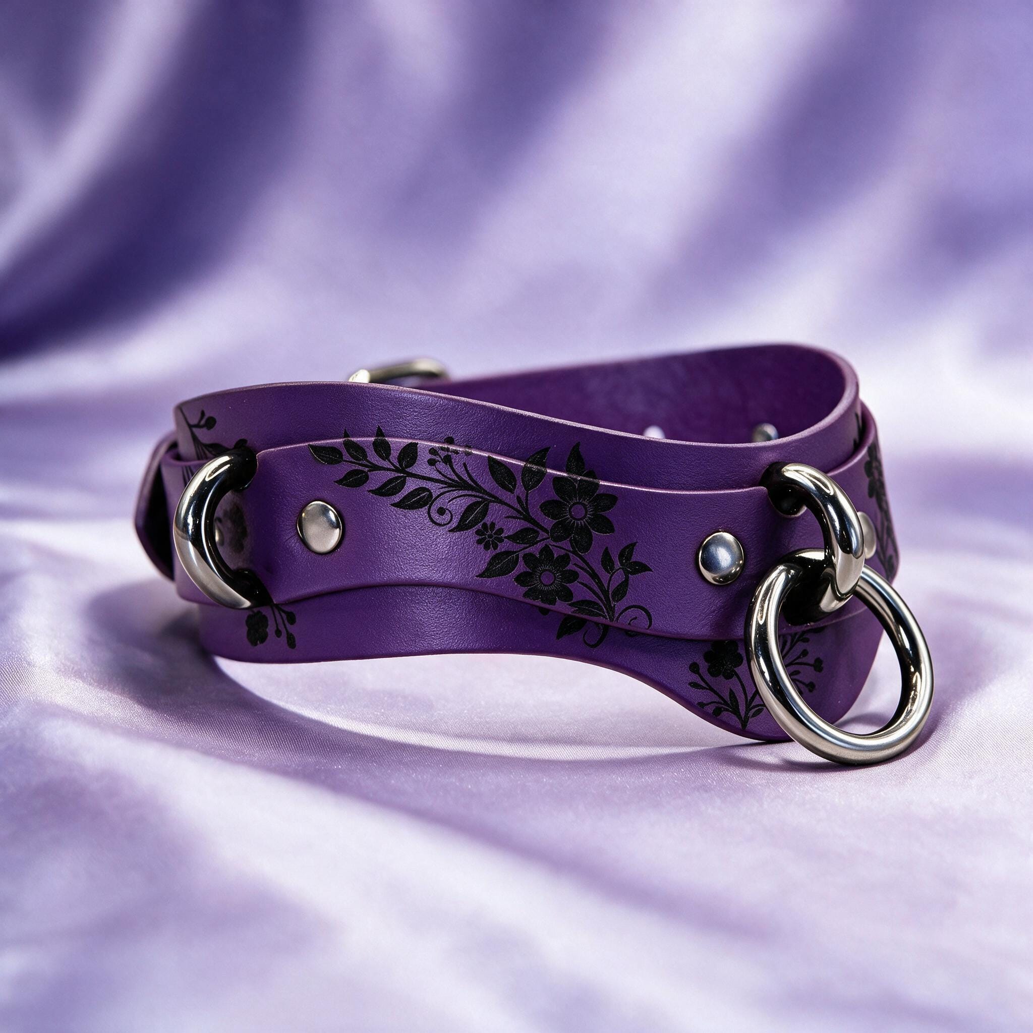 A purple leather choker necklace with a floral design and metal rings.