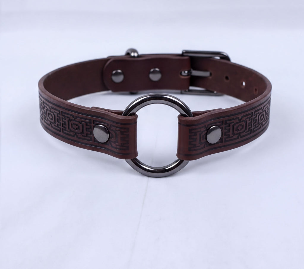 A brown leather choker collar with a metal ring and buckle.