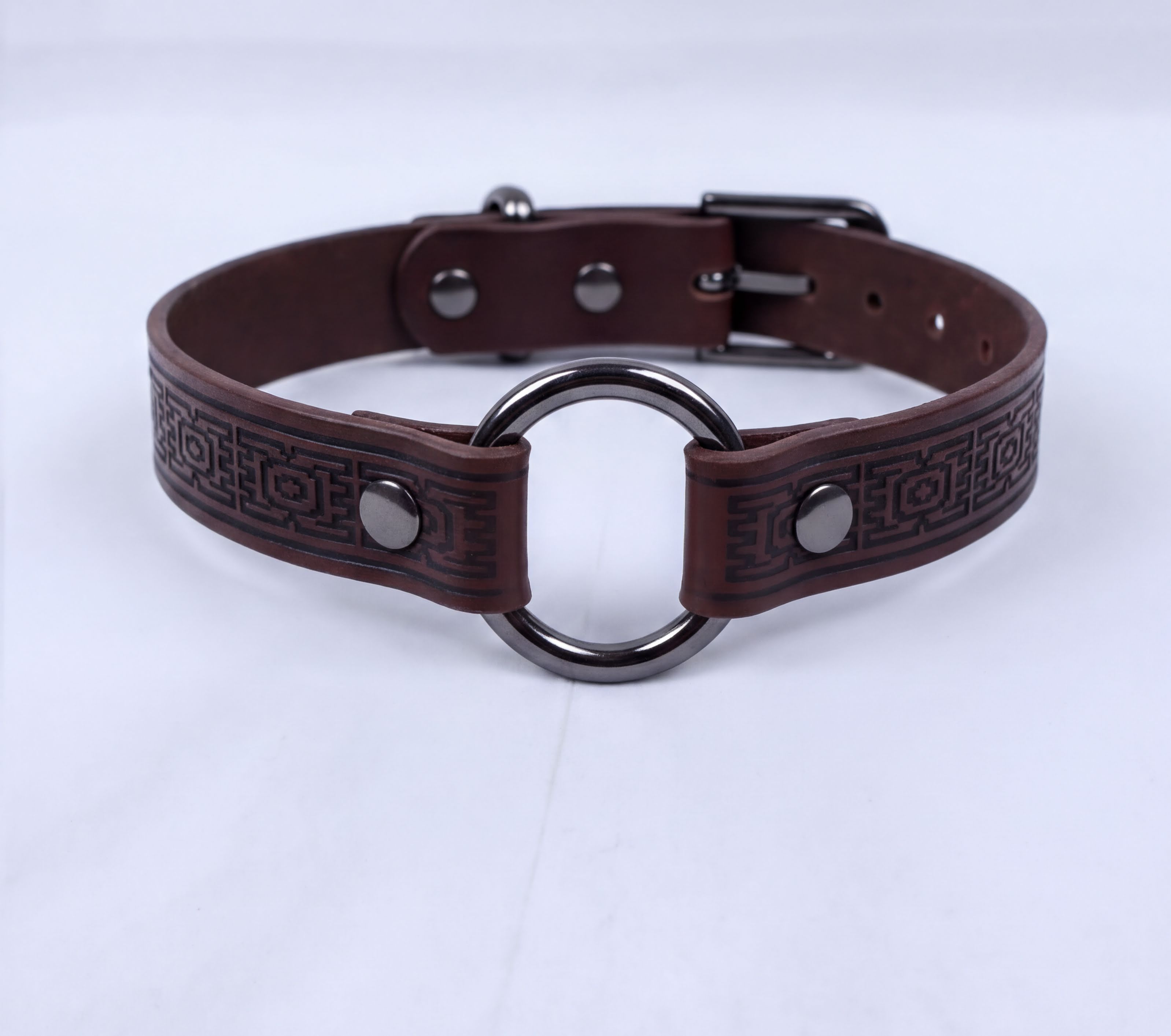 A brown leather choker collar with a metal ring and buckle.