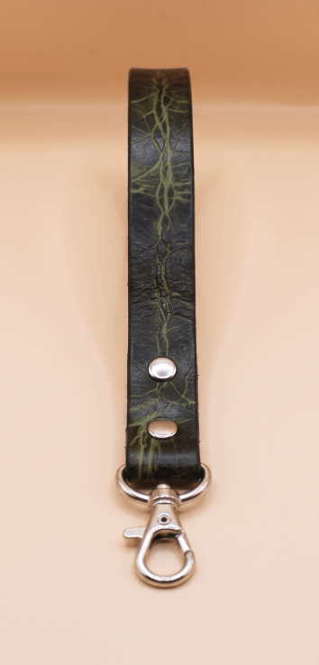 A black leather strap with a silver metal clasp and a green pattern on it.