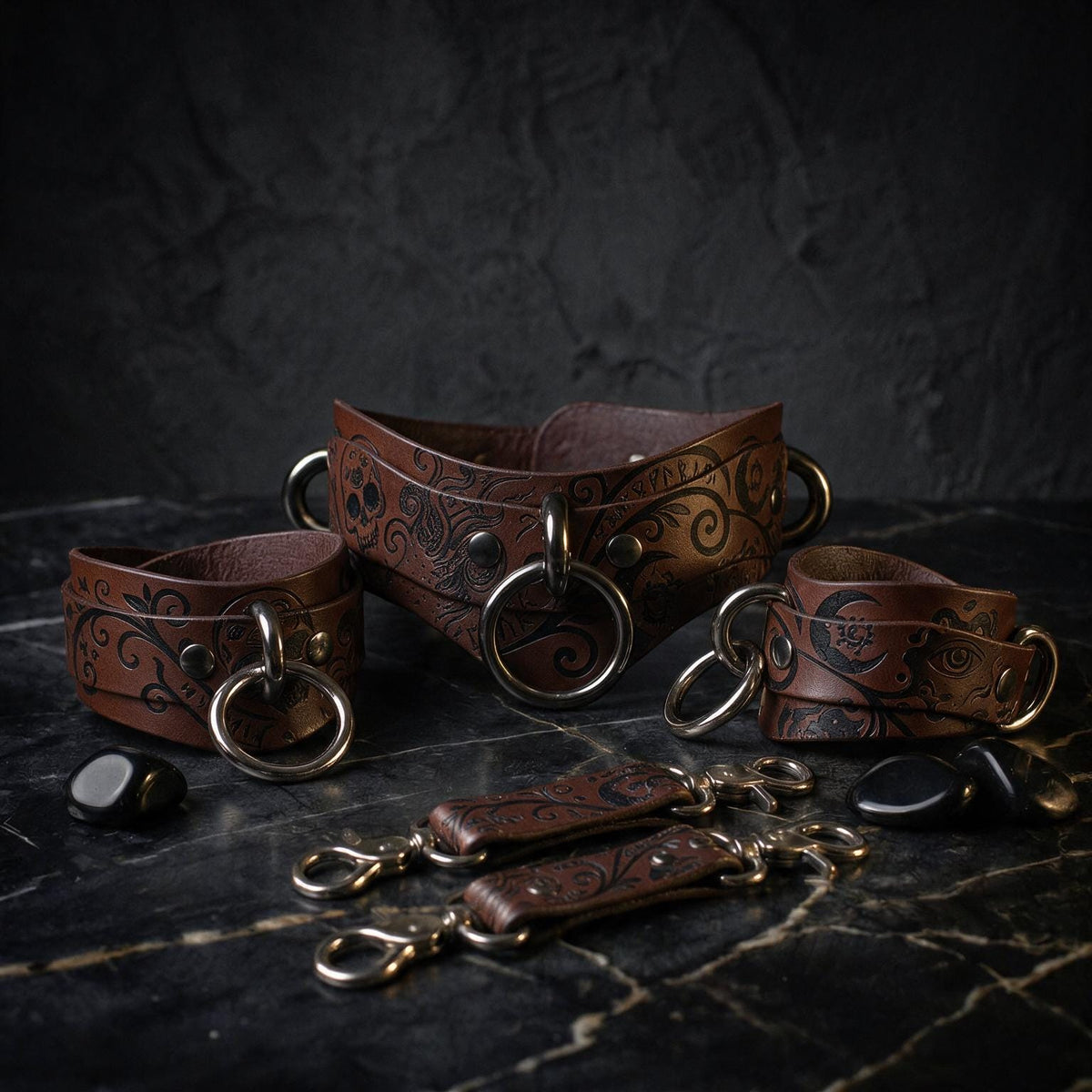 A collection of brown leather straps with metal rings and buckles, arranged on a dark surface.