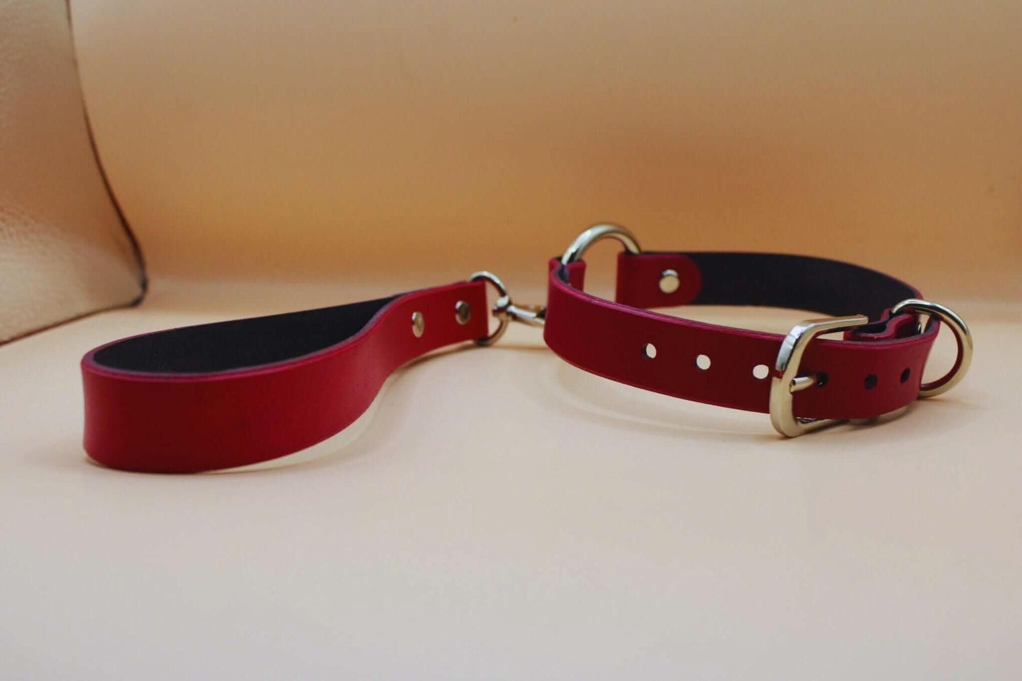 Red leather submissive collar featuring metal rings, perfect for BDSM and bondage gear, enhancing erotic lingerie styles.
