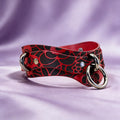 A red and black leather choker necklace with a silver metal ring and a silver metal clasp.