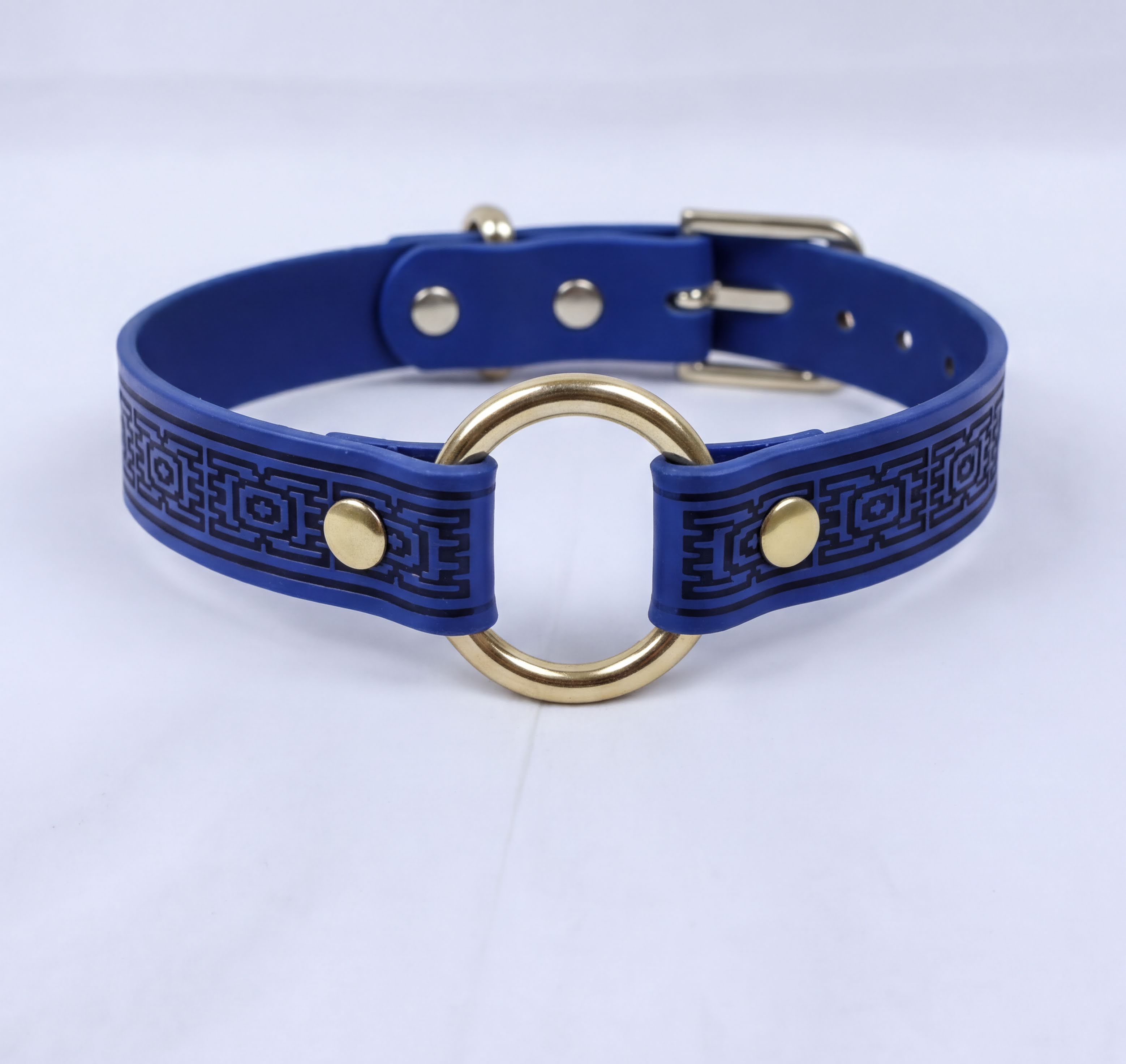 A blue braided collar with a gold ring and buckle.