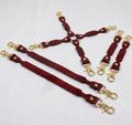 a collection of red leather straps with gold metal clasps, arranged in a way that they appear to be connected or linked together.