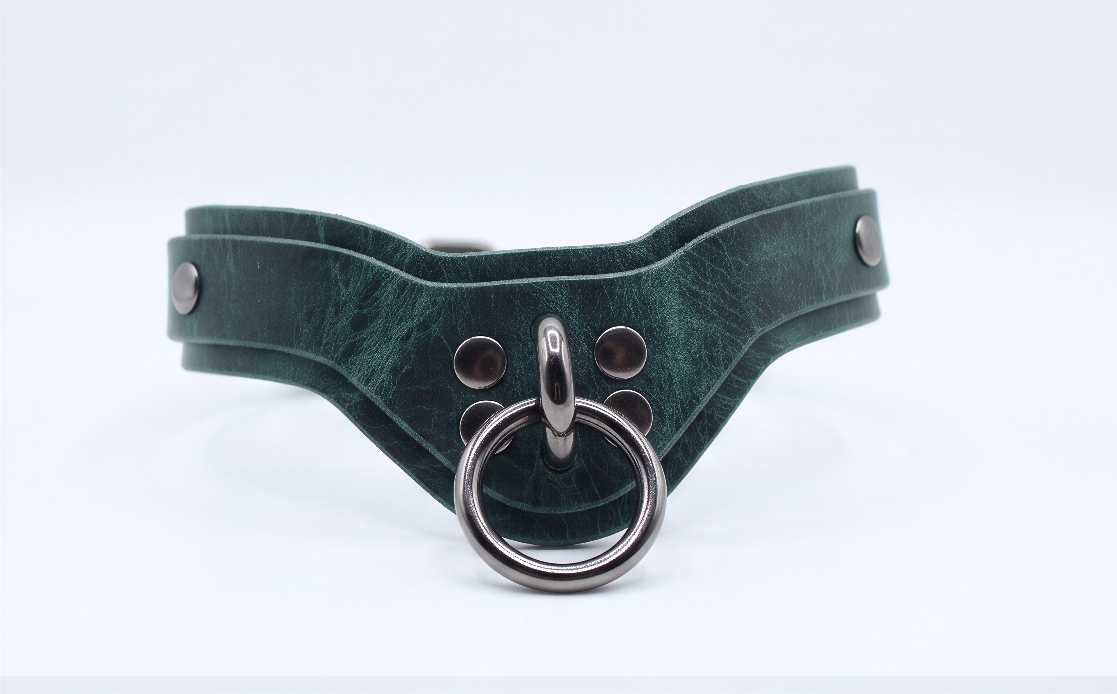 A green leather choker collar with metal studs and a circular metal ring.