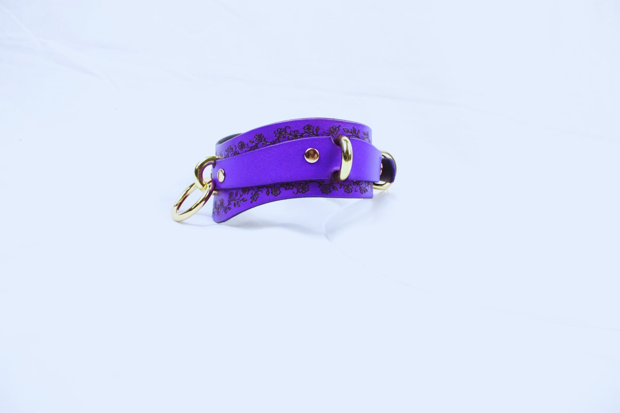 A purple leather strap with a gold buckle is shown against a white background.